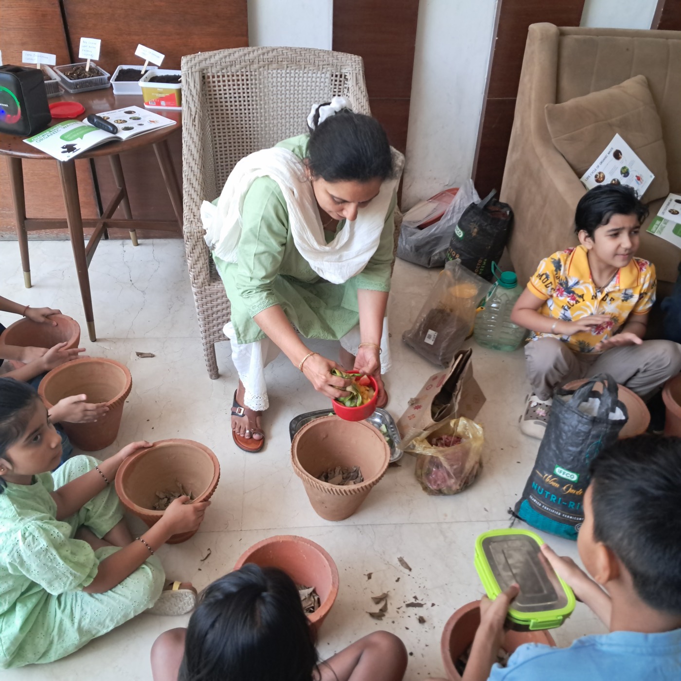 Children preparing to pot plants with compost